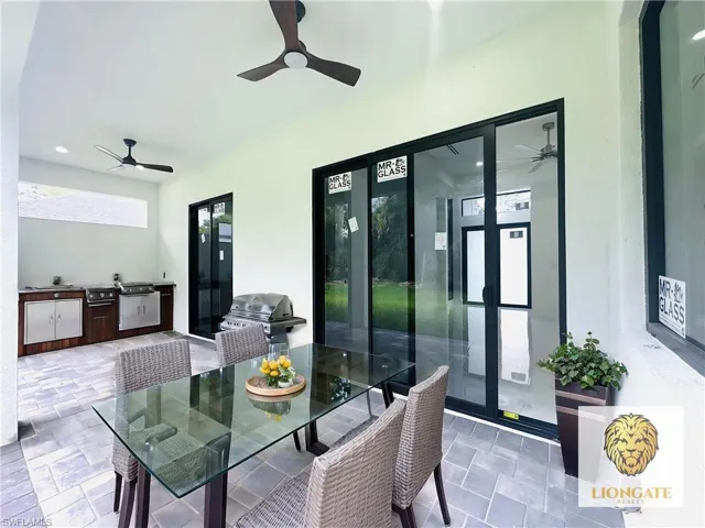 View of patio with ceiling fan, an outdoor kitchen / dining area, and french doors