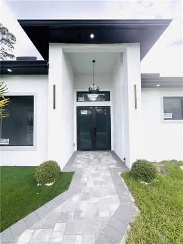 Doorway to property featuring stucco siding and french doors
