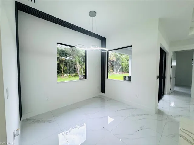 Empty room featuring baseboards and light marble finish floors