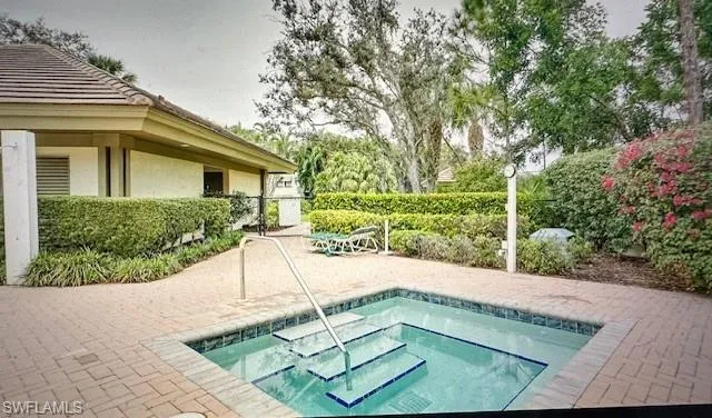 View of pool with a hot tub and a patio