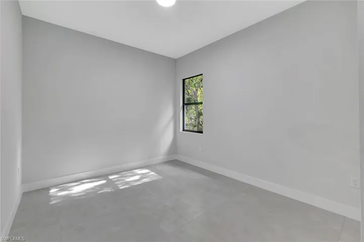 Spare room with baseboards and concrete flooring