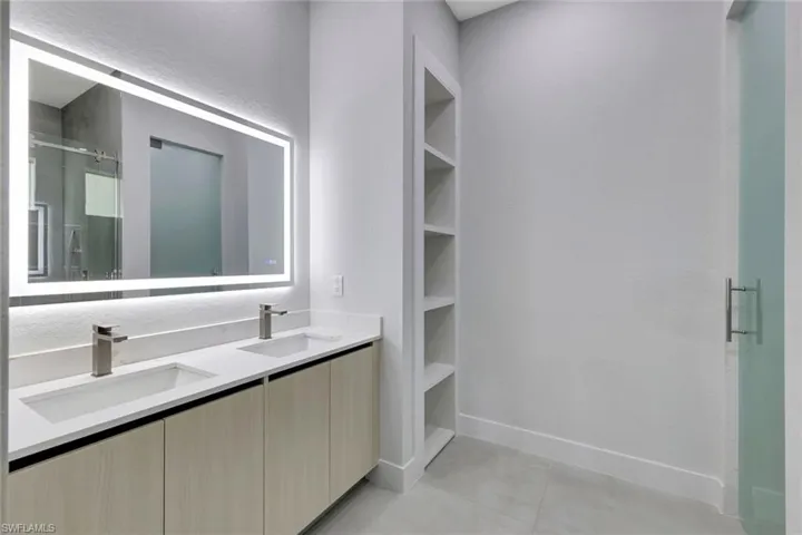 Bathroom featuring a shower stall and double vanity