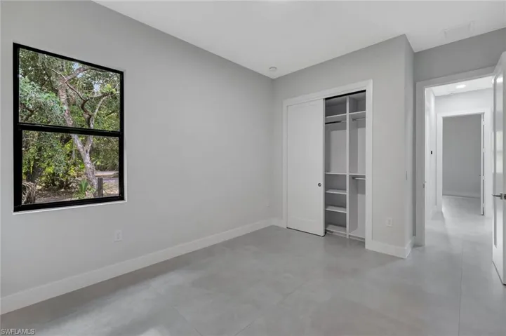 Unfurnished bedroom featuring finished concrete floors and a closet