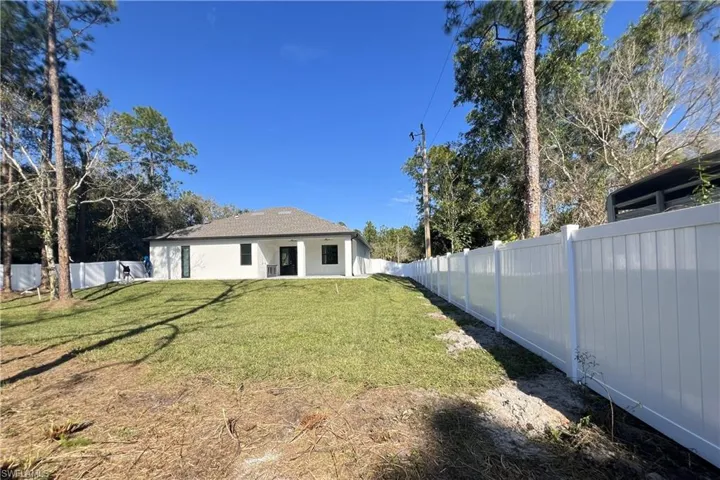 Rear view of property with a fenced backyard and a patio
