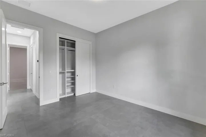 Unfurnished bedroom with concrete flooring and a closet