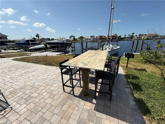 View of patio / terrace featuring boat lift, a boat dock, and a water view
