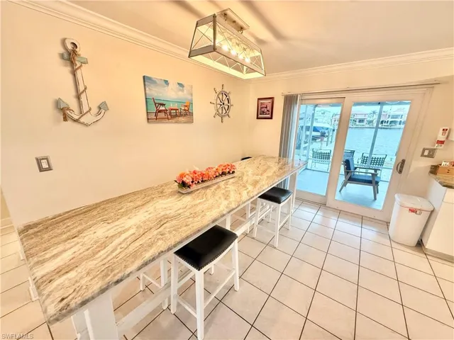 Dining area featuring ornamental molding and light tile patterned flooring