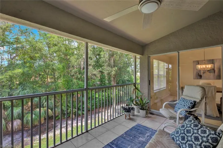 Sunroom with lofted ceiling, ceiling fan, a balcony, and suspended lighting