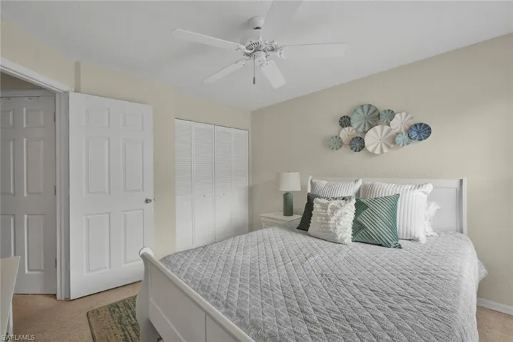 Bedroom featuring light carpet, a closet, and ceiling fan