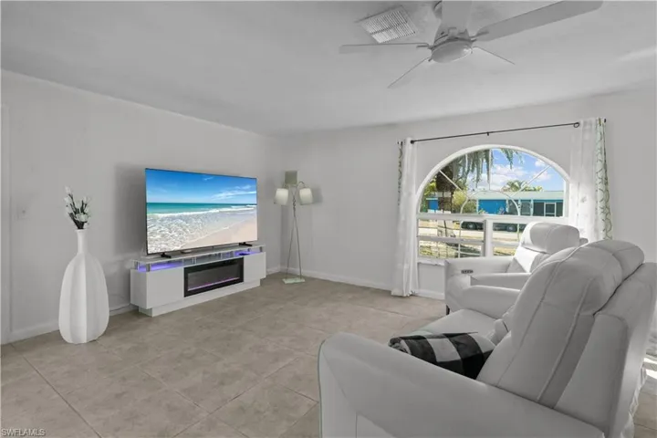 Living area with ceiling fan and light tile patterned floors