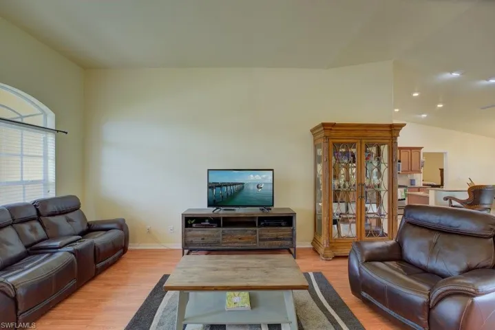 Living room with light hardwood / wood-style flooring and lofted ceiling