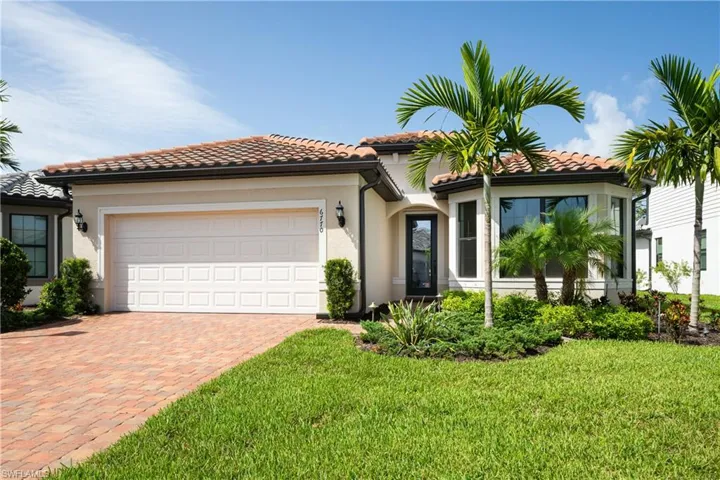 Mediterranean / spanish-style house featuring an attached garage, decorative driveway, stucco siding, and a front lawn