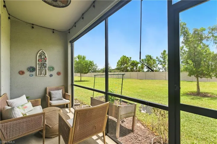 Private screened lanai with ample space for seating and entertaining, offering serene views of the landscaped common area.