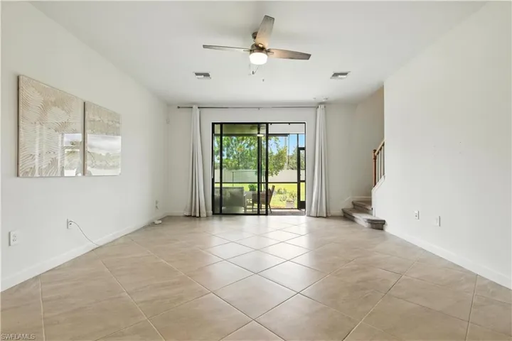 Spacious main living area with tile flooring, neutral finishes, and sliding glass doors that bring in natural light.