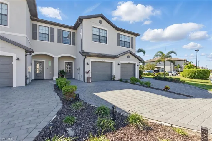 Modern townhome-style exterior with paver driveway, 1-car garage, and well-maintained landscaping in a newer construction community.