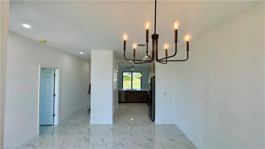 Unfurnished dining area with an inviting chandelier and light tile floors