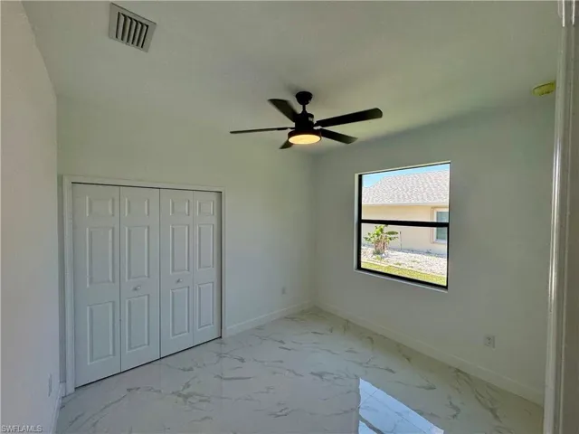 Unfurnished bedroom with a closet, ceiling fan, and tile floors