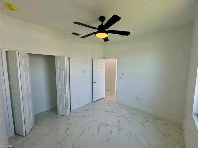 Unfurnished bedroom featuring ceiling fan, a closet, and light tile flooring