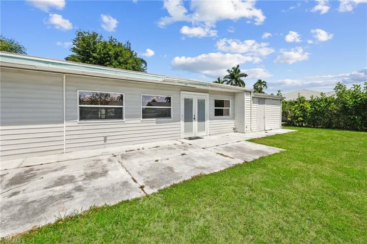 Rear view of house featuring a yard, french doors, and a patio area