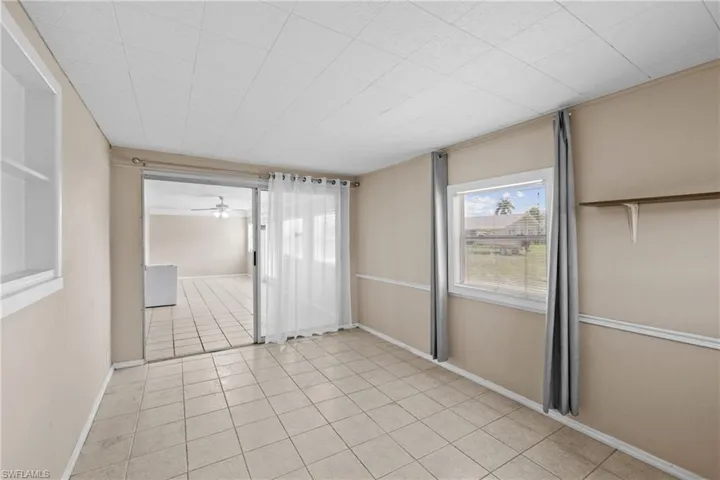 Tiled spare room with ceiling fan