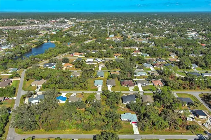 Aerial view of property and surrounding area with nearby suburban area and a large body of water