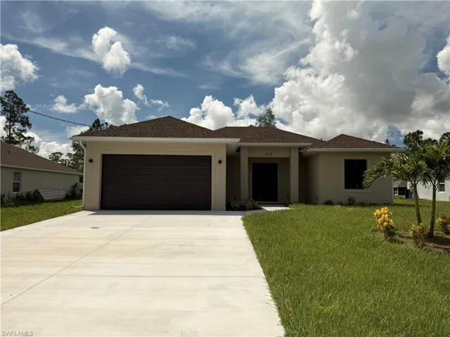 Exterior showcasing a neutral stucco finish, a two-car garage with a dark panel door, a concrete driveway, and a shingle roof
