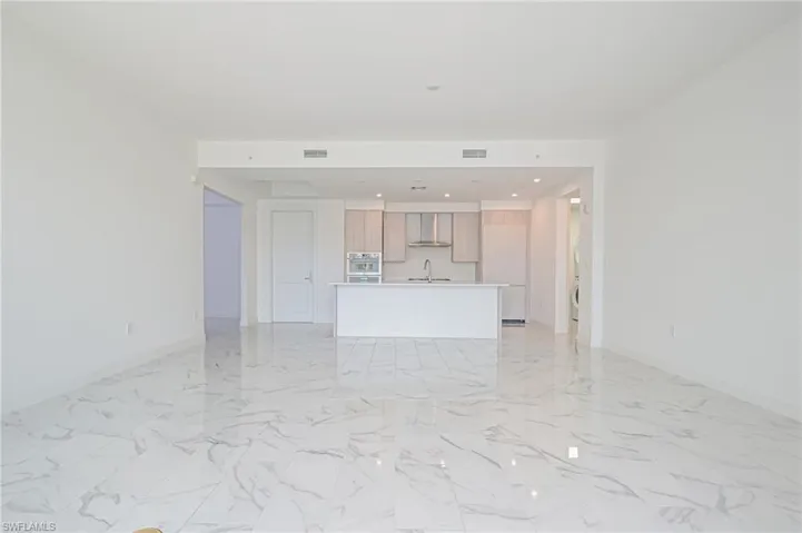 Bright and light with den to the left and open floorplan with kitchen, dining, and living room