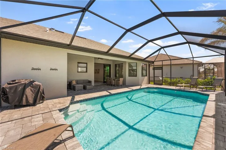 Outdoor pool featuring a lanai, an outdoor living space, a patio area, and a ceiling fan