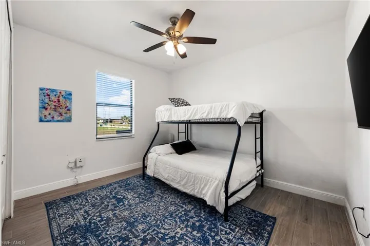 Bedroom with baseboards, a ceiling fan, and wood finished floors