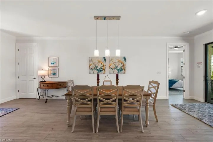 Dining room with ornamental molding, baseboards, and wood finished floors