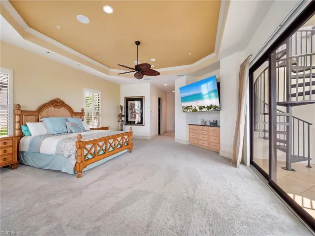 Carpeted bedroom featuring a tray ceiling, access to outside, ornamental molding, recessed lighting, and a ceiling fan
