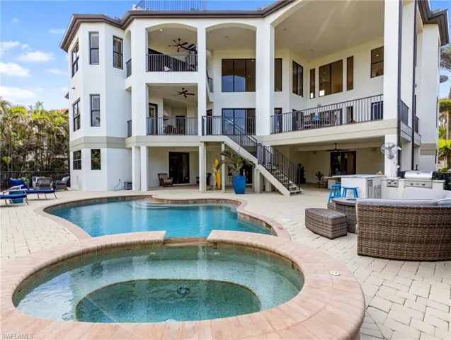 View of swimming pool featuring an outdoor living space, an outdoor bar, ceiling fan, an in ground hot tub, and a patio area
