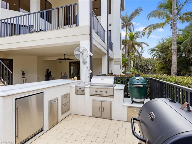 View of patio featuring area for grilling, ceiling fan, and a balcony