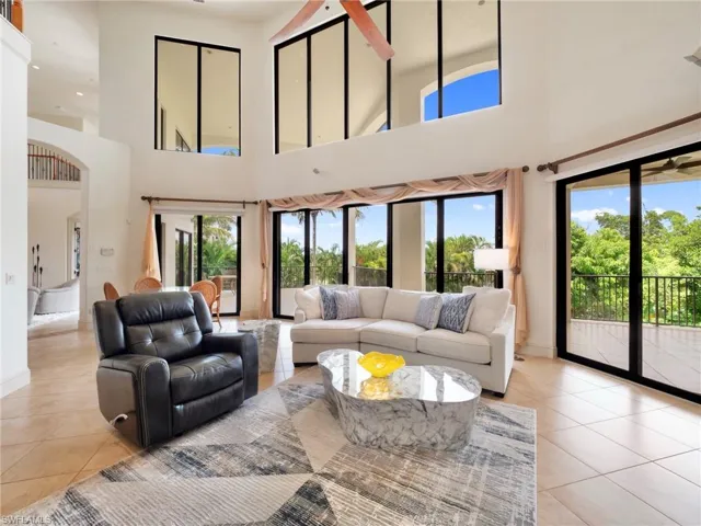 Living room featuring a high ceiling, healthy amount of natural light, and light tile patterned flooring