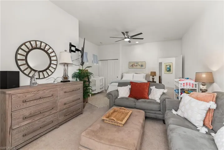 Bedroom featuring light carpet, ceiling fan, and a closet