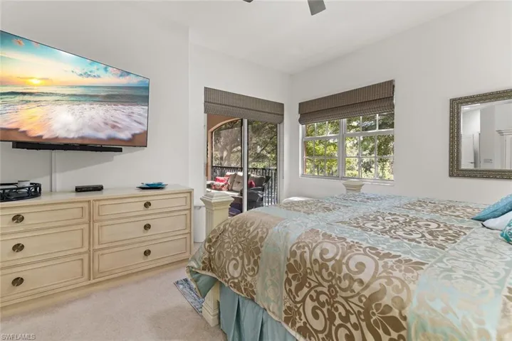 Bedroom featuring access to outside, a ceiling fan, and light colored carpet