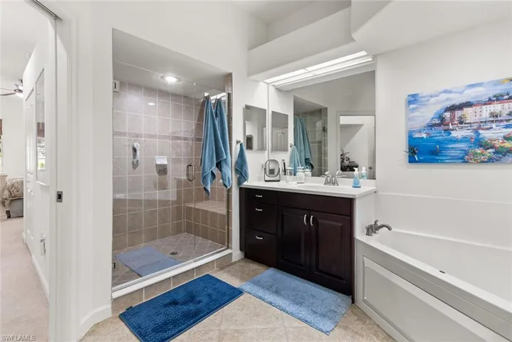 Full bath featuring tile patterned floors, ensuite bathroom, a garden tub, vanity, and a shower stall