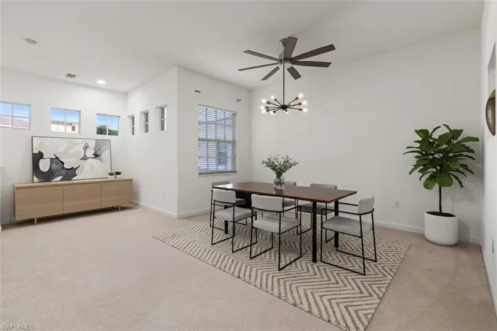 Dining room with light carpet, healthy amount of natural light, and ceiling fan