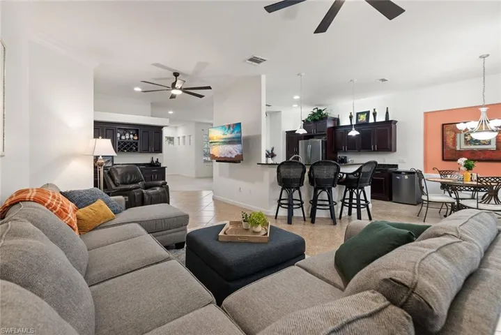 Living room featuring light tile patterned floors, ceiling fan, and recessed lighting
