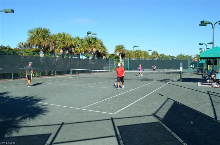 View of tennis court featuring fence