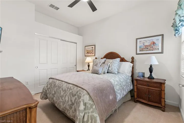 Bedroom with baseboards, visible vents, a ceiling fan, light colored carpet, and a closet