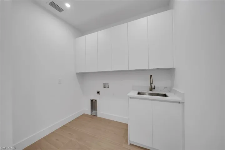Garage featuring electric panel, recessed lighting, and a garage door opener