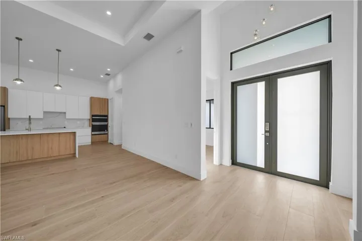 Kitchen with modern cabinets, light wood-style flooring, white cabinets, tasteful backsplash, and recessed lighting