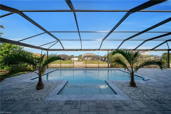 View of swimming pool featuring a patio area and glass enclosure