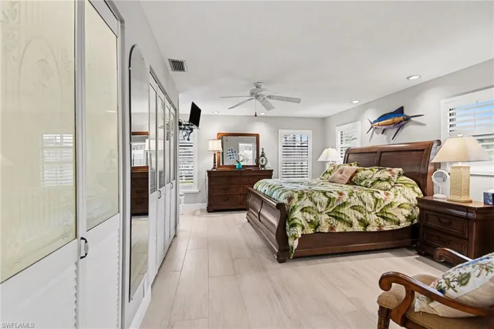 Bedroom with ceiling fan, multiple windows, light wood-type flooring, and recessed lighting