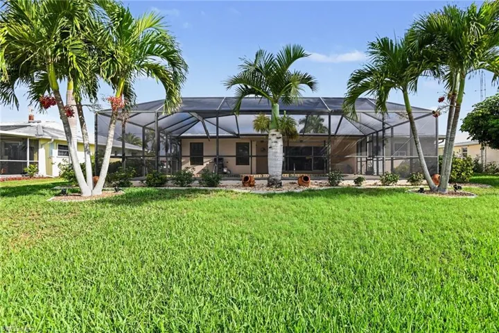 Back of house featuring a sunroom, a yard, a lanai, and a patio area