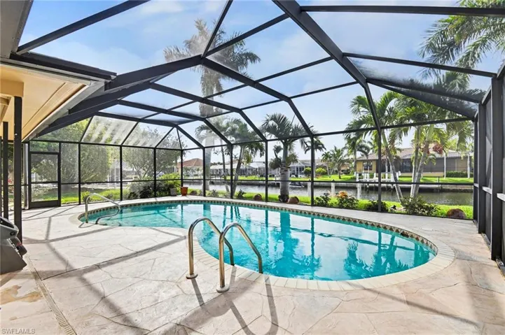 Outdoor pool with a sunroom, a water view, a lanai, and a patio area