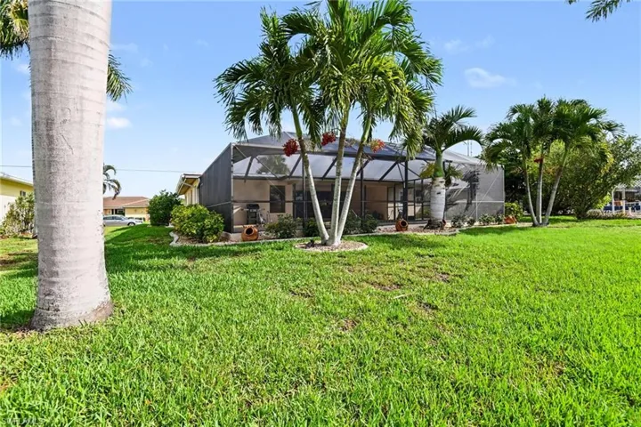 Back of property with a yard, a sunroom, and glass enclosure