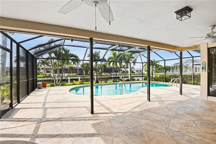Swimming pool with a patio area, a sunroom, and glass enclosure