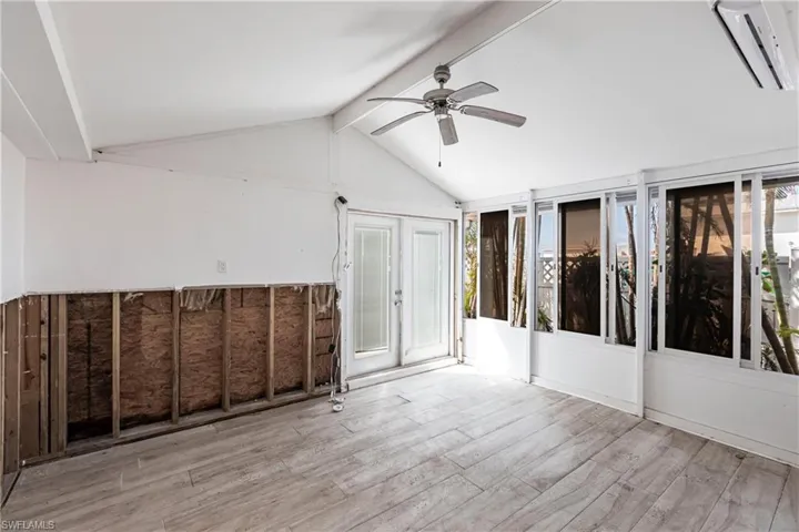 Unfurnished sunroom featuring a wall mounted air conditioner